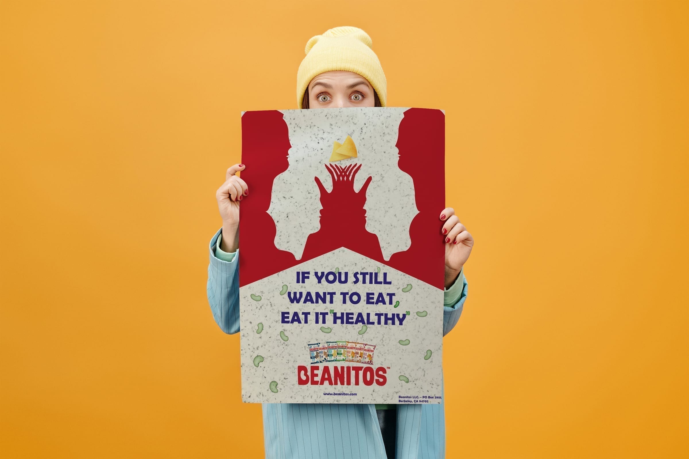 Person holding the poster against an orange wall.