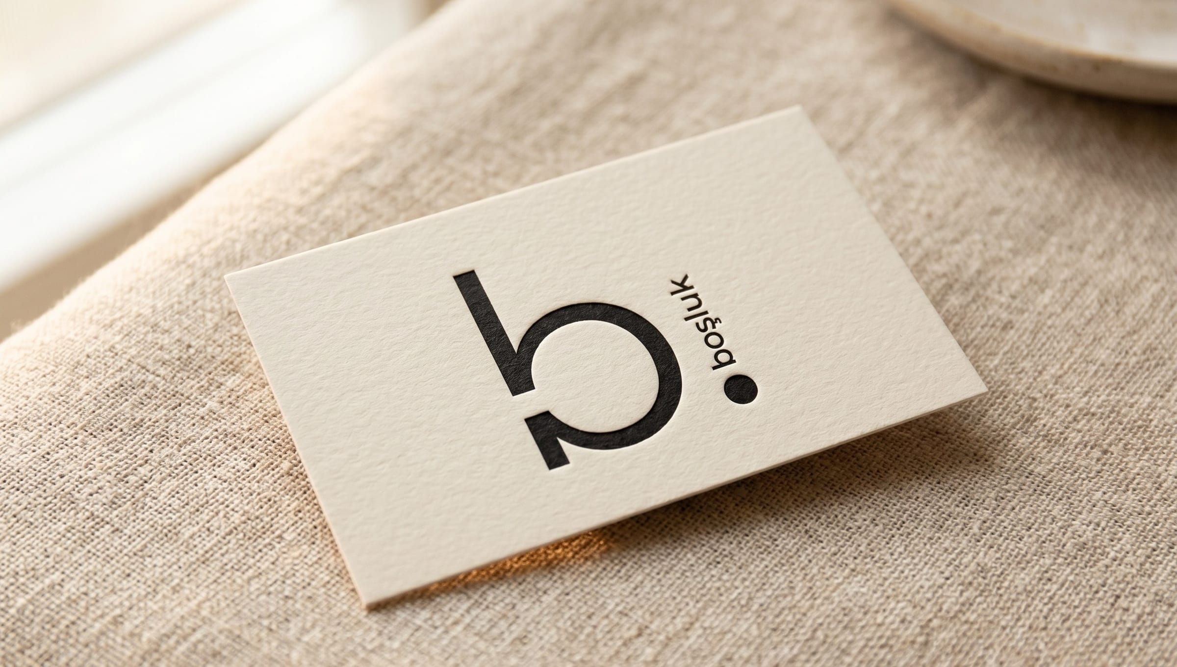 Boşluk business card resting on a linen surface, logo and minimal typography.