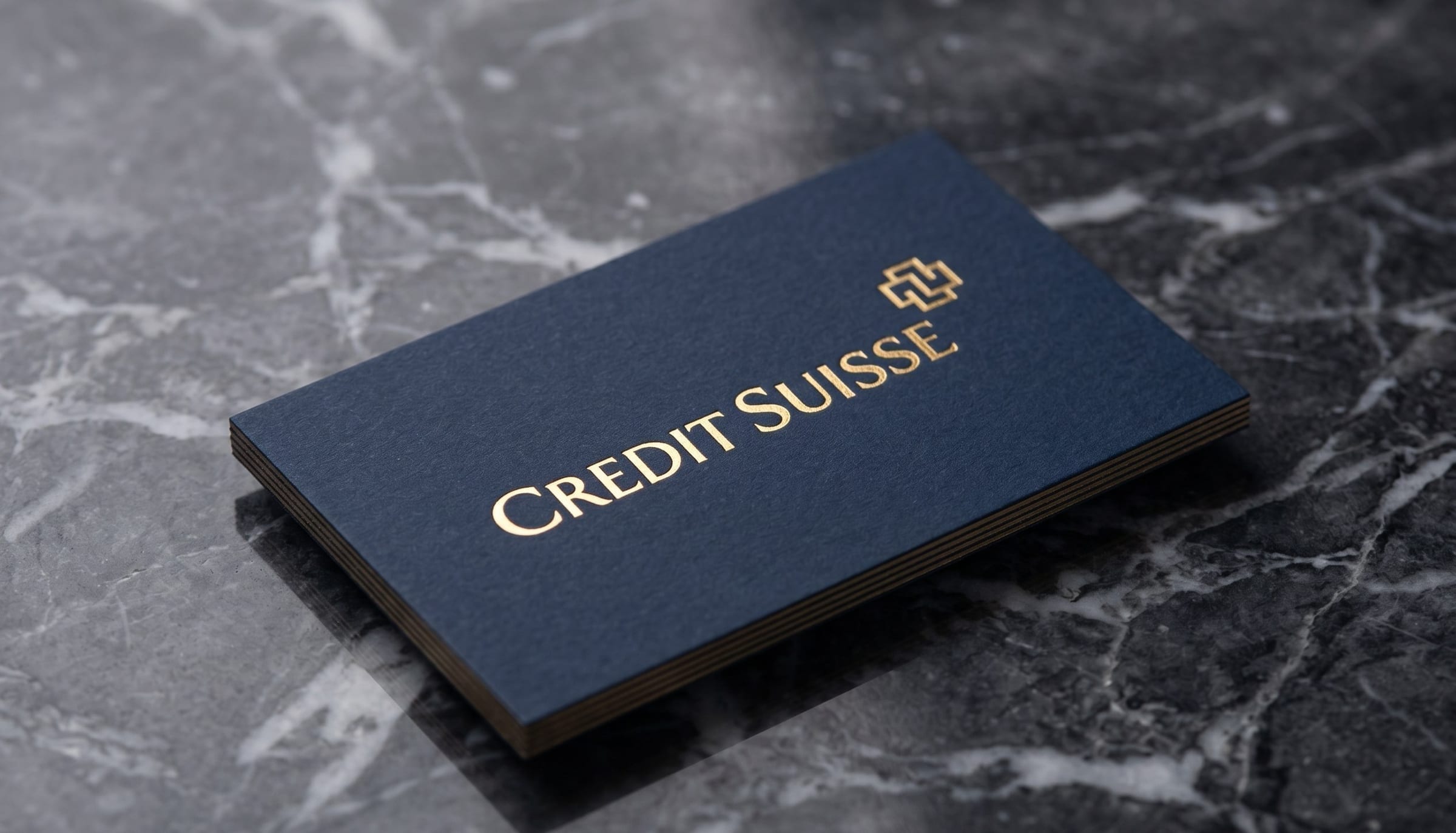 Credit Suisse business card on dark marble, rebranded with the Wermelinger cross.
