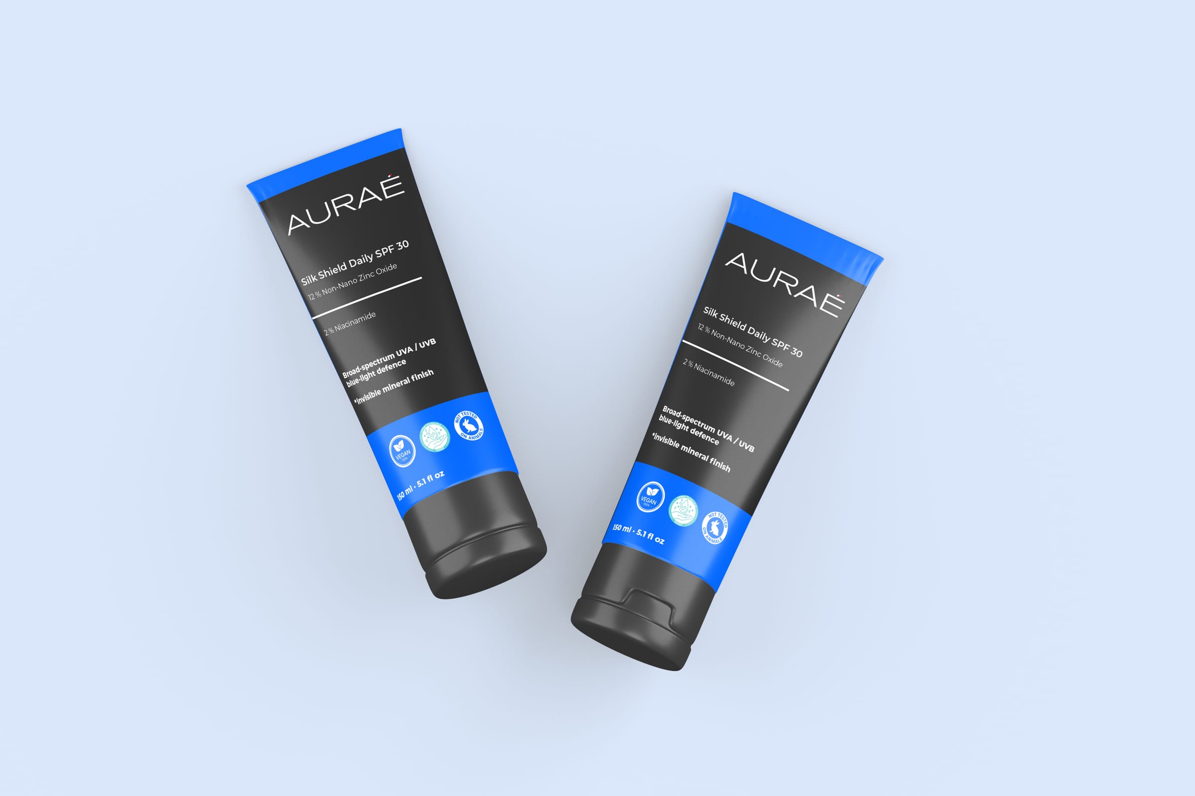 Two AURAÉ Silk Shield Daily SPF 30 tubes on a pale blue background.