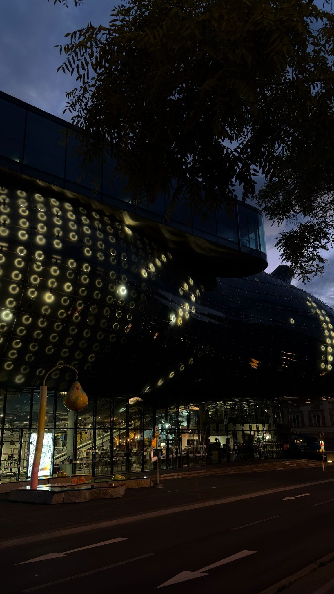 Close-up of the Kunsthaus Graz BIX facade at night, showing the grid of illuminated rings mid-pattern.