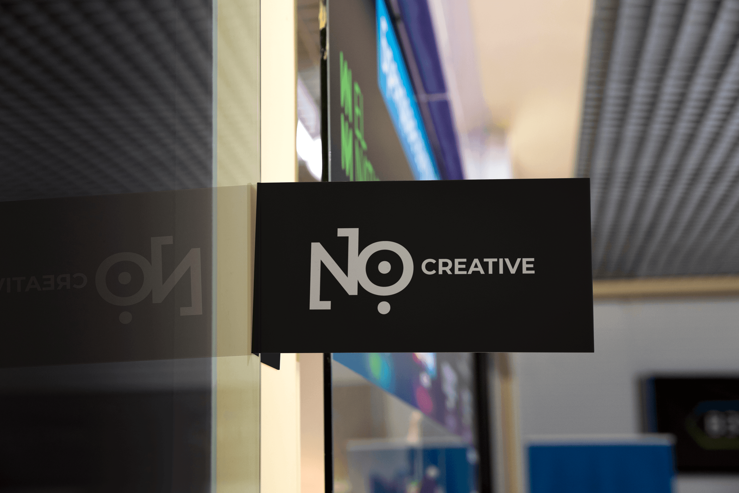 NO:118 Creative office door sign, white logo on black panel mounted beside glass door.